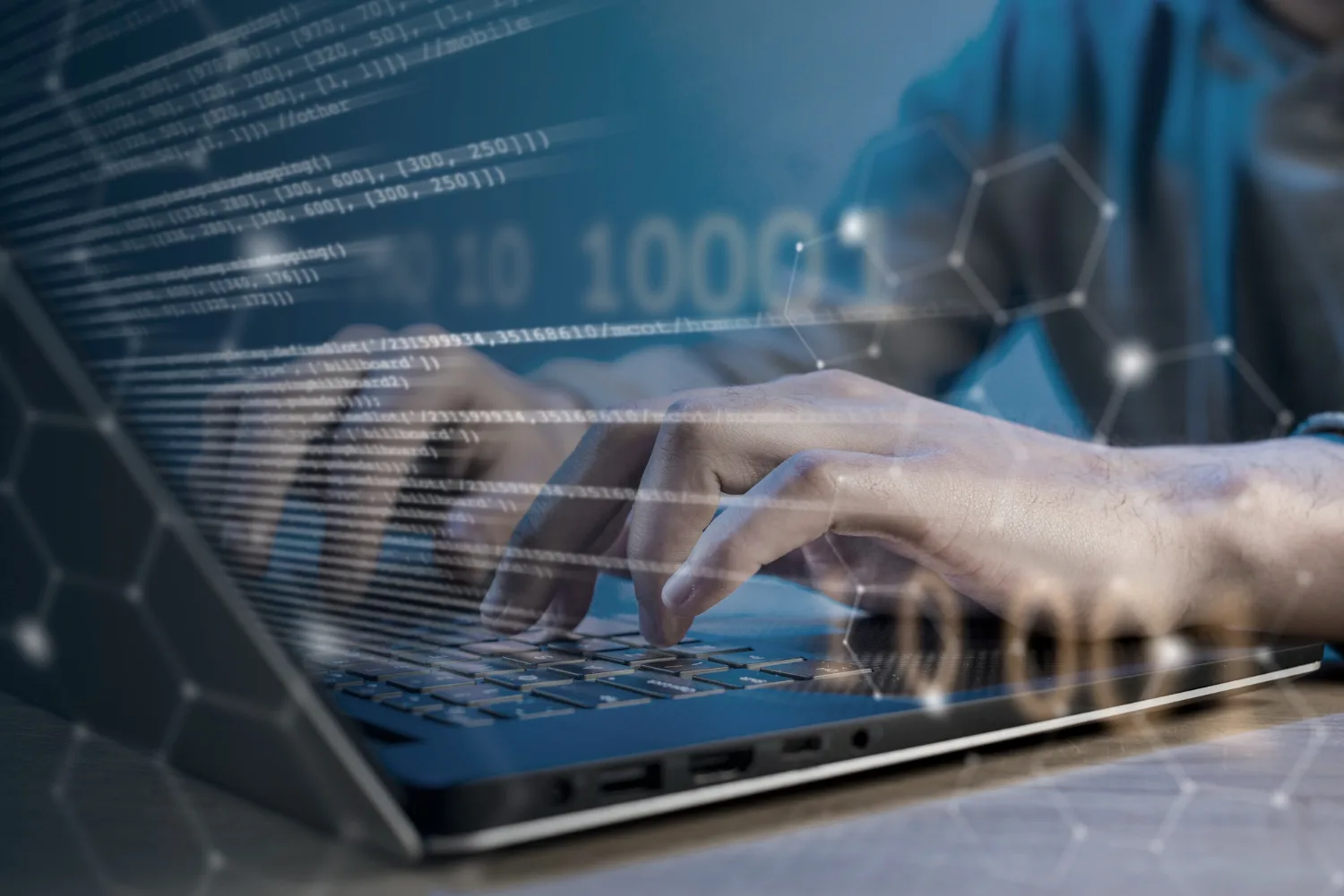 Stock photo of hands typing on a laptop keyboard with an overlay of binary code and network graphics, symbolizing software prototyping